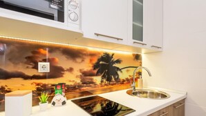 A kitchen with a modern design, featuring a built-in stove, a sink, and wooden cabinets.
