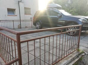 A parking area with a metal fence and a parked SUV. - Family-friendly Crikvenica Retreat (Crikvenica)