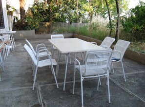 An outdoor patio with a rectangular table and six white chairs. - Family-friendly Crikvenica Retreat (Crikvenica)