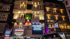 A multi-story hotel with balconies, a sign for 'Motel Ambrosia', and various other signs indicating local businesses. - Hotel Ambrosia (Gangtok)