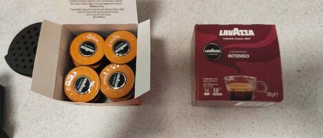 A box of Lavazza espresso coffee pods and a coffee maker.