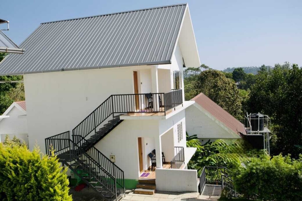 A two-story building with a metal roof, a staircase leading to the upper floor, and a balcony.