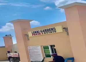 Ein Gebäudeeingang mit einem Schild, auf dem 'Lekki Gardens Phase 3 Estate' steht.