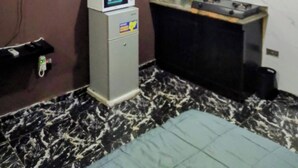 A compact kitchen with a microwave, a small refrigerator, a sink, and a wooden cabinet above it. - Short Let in lagos business school Ajah  (Lekki)