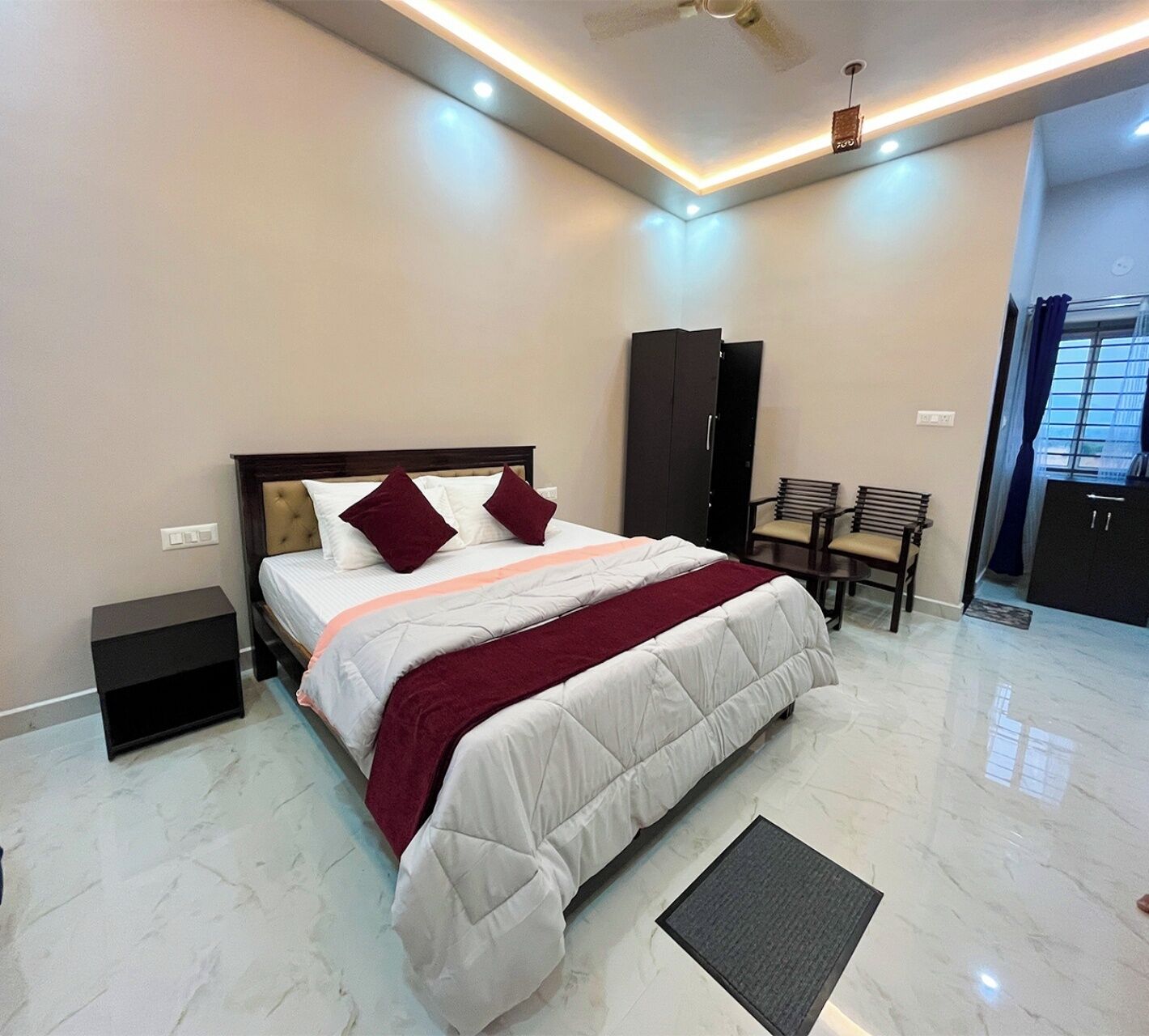 A modern hotel room with a large bed, a desk, and a chair.
