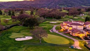 Un campo de golf con un club de campo y edificios residenciales.