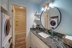 A bathroom with a sink, mirror, and two washing machines. - Coastal Condo + Near Oso Bay & Padre Beaches | Seaside Haven (Corpus Christi)
