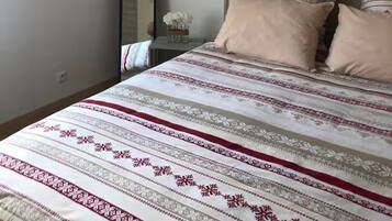 Una camera da letto con un letto, un comodino, uno specchio e una lampada a parete.