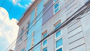 A building with a modern architectural style, featuring a curved overhang with colorful decorations, large windows, and a visible signboard. - baoly clark residence (Angeles City)