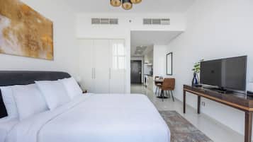 Une chambre d’hôtel moderne équipée d’un grand lit, d’une télévision et d’un coin repas.