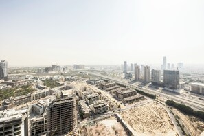 Een stadsgezicht met hoogbouw, wegen en bouwplaatsen.