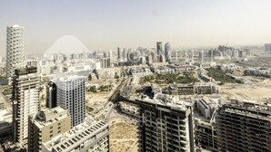 A high-rise building with multiple floors and a modern architectural design. - Bloomfields Cozy Stu Damac (Dubai)
