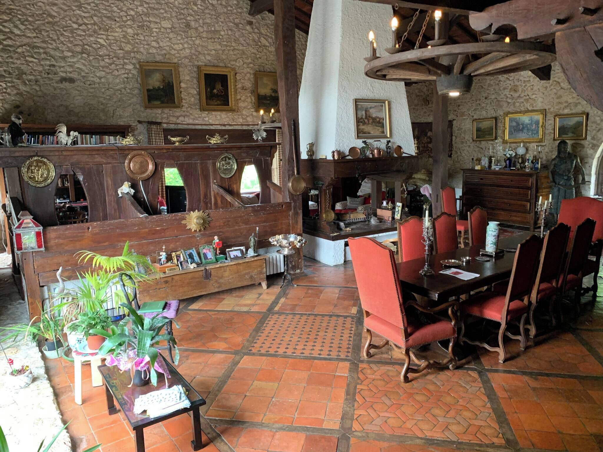 A rustic interior with a stone wall, wooden furniture, and various decorative items.