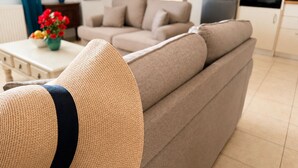 Ein Wohnzimmer mit einer Couch, einem Couchtisch und einer Küchenzeile mit Geräten.