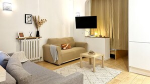 A modern living room with a beige sofa, a grey couch, a wooden coffee table, and a white radiator. - Bright haven between Champs Élysée and Trocadero (Paris)