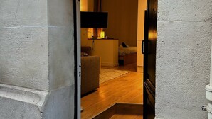 An arched doorway leading into a room with a bed, a desk, and a television. - Bright haven between Champs Élysée and Trocadero (Paris)