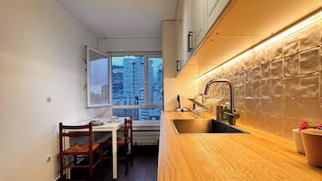 Una cocina moderna con encimera de madera, estufa integrada y ventana con vistas a la ciudad.