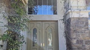 A double door with a small window above it, a stone wall to the right, and a small step leading up to the door. - Dream house (Salinas)