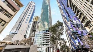 Un gruppo di moderni grattacieli dalle facciate riflettenti, circondati da alberi e altre costruzioni urbane.