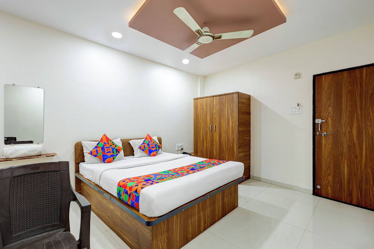 Un dormitorio con cama, armario, ventilador de techo y espejo.