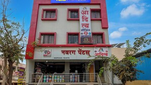 A building with a sign for 'fabHOTELS' at the top, a sign for 'NAVRANG PAINTS' below, and solar panels on the roof. - Fabhotel Aditya Lodging (Chhatrapati Sambhajinagar)