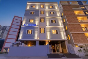 A modern multi-story hotel with a prominent 'fab-hotels' sign, multiple balconies, and a well-lit entrance. - Fabhotel High Rise Kokapet (Hyderabad)