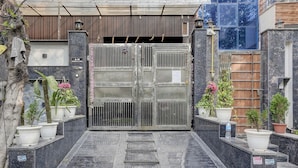 A gated entrance with a marble pathway leading to a building entrance. - Fabhotel Ivory Loft (Noida)