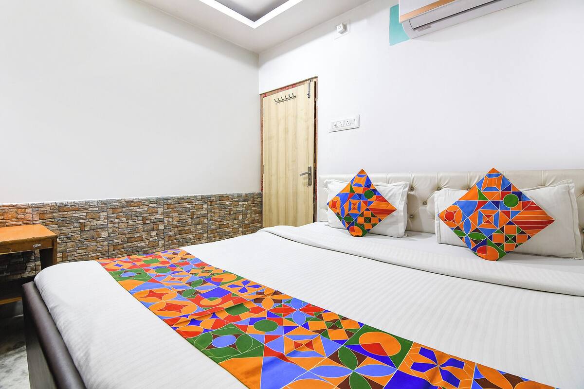Ein Hotelzimmer mit einem Bett, einer Wand mit Steinverkleidung, einer Holztür und einer weißen Decke.