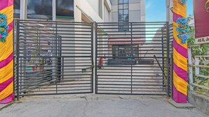 Un cancello chiuso con una grata metallica, un edificio con tenda rossa e bianca e un cartello con il numero 48/8.