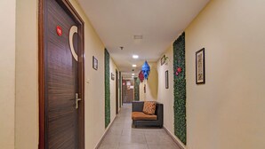 Un corridoio con una porta in legno, una reception e un cartello a parete.
