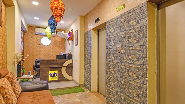Una hall d'albergo dal design moderno, con reception, area salotto e elementi decorativi come lanterne appese.