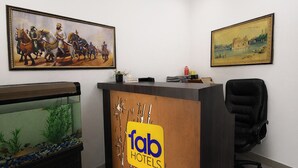Una recepción con el cartel de 'Fab Hotels', un cuadro histórico enmarcado y un acuario.