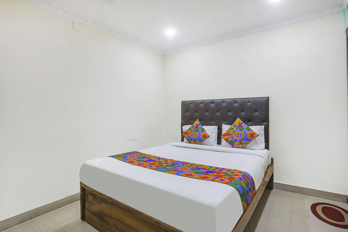Une chambre à coucher avec un lit, une tête de lit et une couvre-lit à motifs.