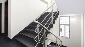 A modern staircase with metal railings, leading to a landing with a window. - Fabhotel The Corporate Inn I (Kolkata)