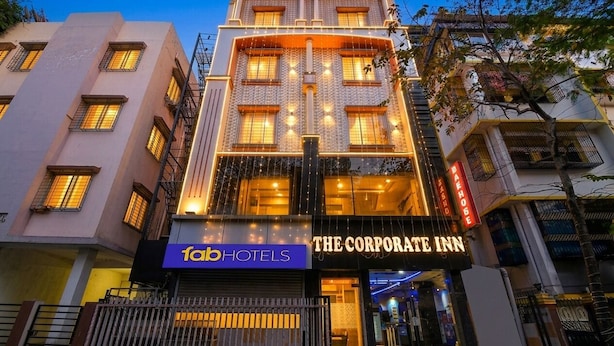 A multi-story building with a sign for 'The Corporate Inn' and 'fabHOTELS' on the ground floor. - Fabhotel The Corporate Inn I (Kolkata)