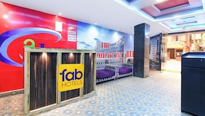 A hotel reception area with a reception desk, a check-in counter, and a wall with a corporate theme. - Fabhotel The Corporate Inn I (Kolkata)