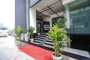 A hotel entrance with a red carpet, potted plants, and a sign reading "HOTEL URBAN VILLA". - Fabhotel Urban Villa I (Noida)