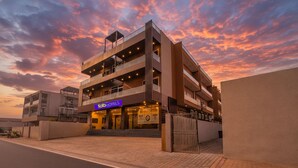 A modern hotel with a multi-story structure, a prominent 'abHOTELS' sign, and a gated entrance.