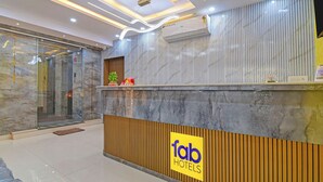 A hotel reception desk with a marble wall, a wooden panel, and a sign reading "Tab Hotels". - Fabhotel Disa (Kolkata)