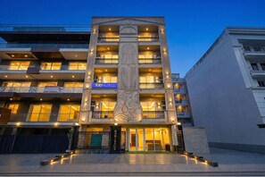 A multi-story hotel with balconies, a central decorative column, and a sign for 'fab hotels'. - Fabhotel Heritage Inn Golf Course Rd (Gurugram)