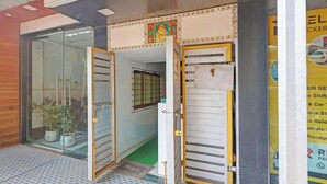 A hotel entrance with glass doors, a small indoor garden, and a visible reception area. - Fabhotel Ar Residency (Mumbai)