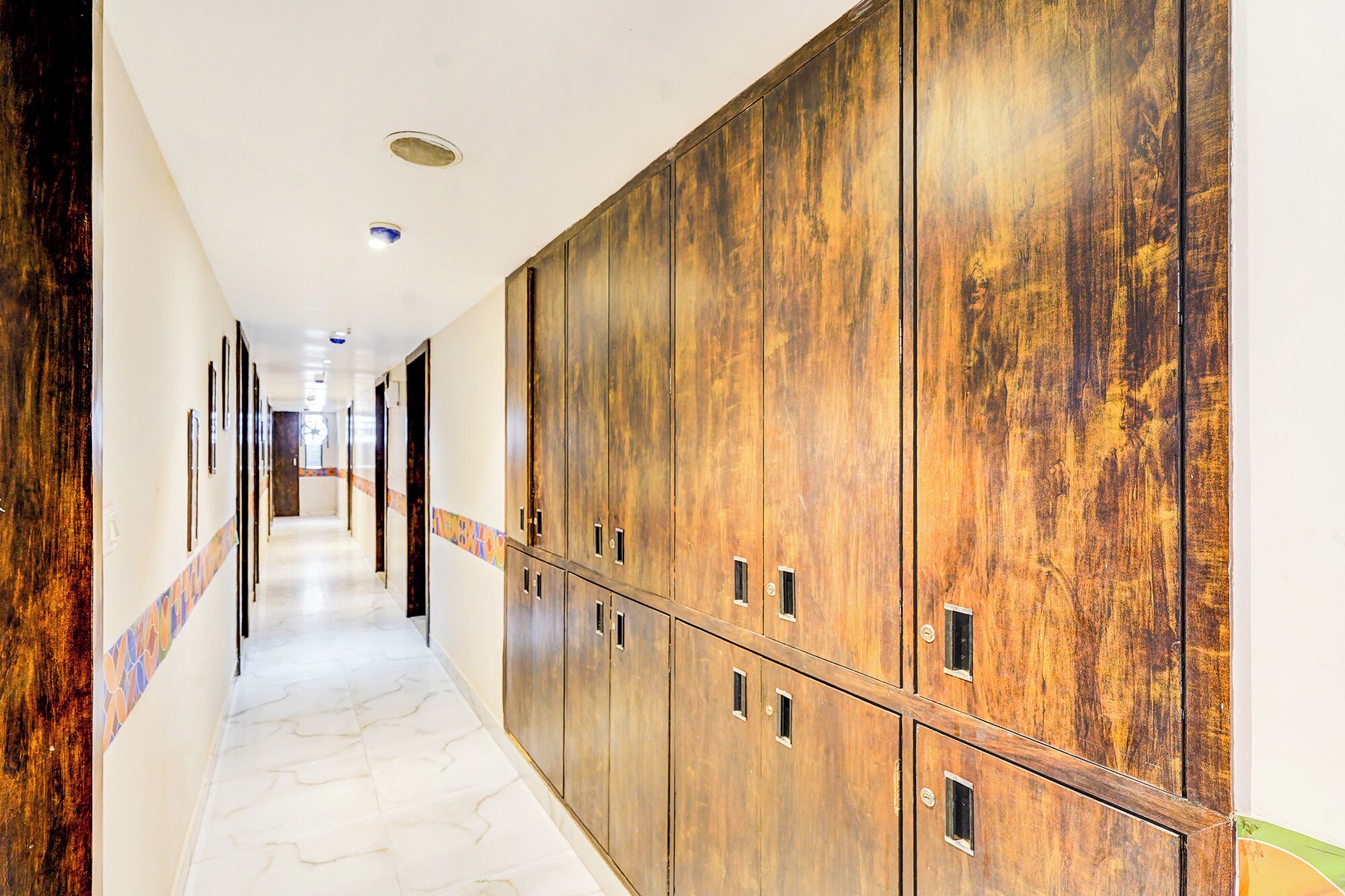 A long hallway with lockers and a clock on the wall.