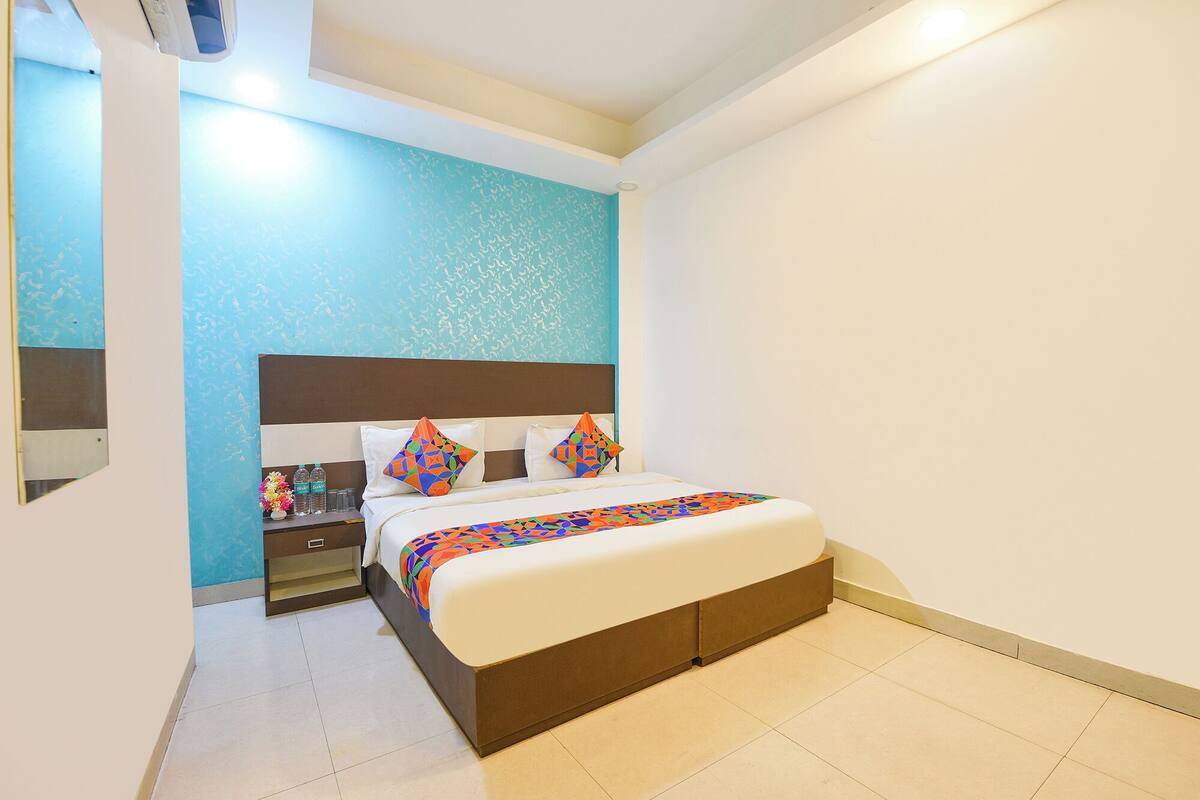 A hotel room with a bed, nightstands, and a mirror.