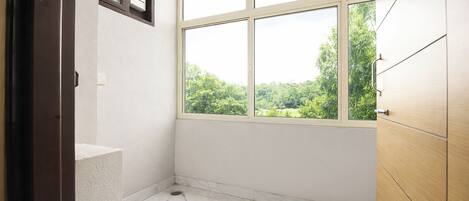 A room with a large window, a wooden door, and a marble floor.
