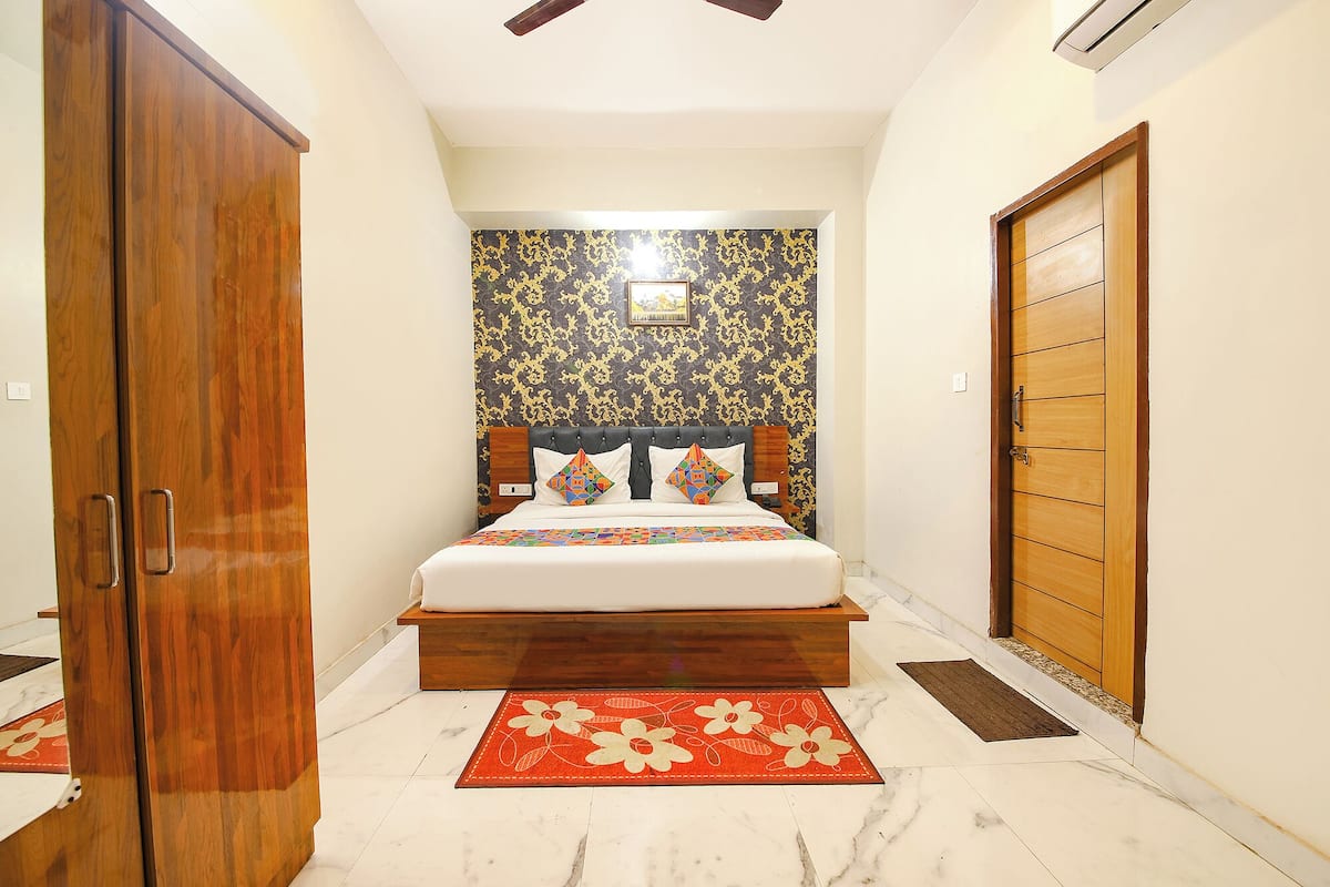 Un dormitorio con cama, armario de madera, puerta y pared con diseño.