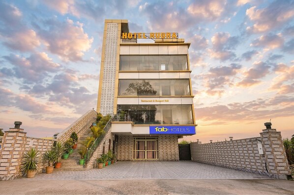A modern hotel with a prominent sign, a staircase, and a restaurant. - Fabhotel Rudra (Rishikesh)