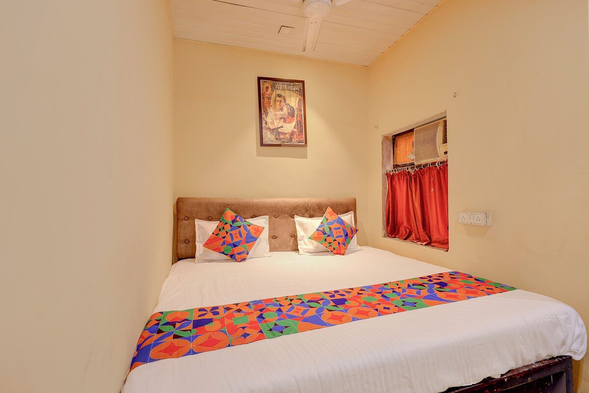 A bed with a colorful geometric bedspread, a headboard, and two pillows.