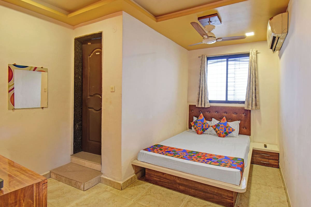 Un dormitorio con cama, ventana con cortinas, ventilador de techo y puerta.