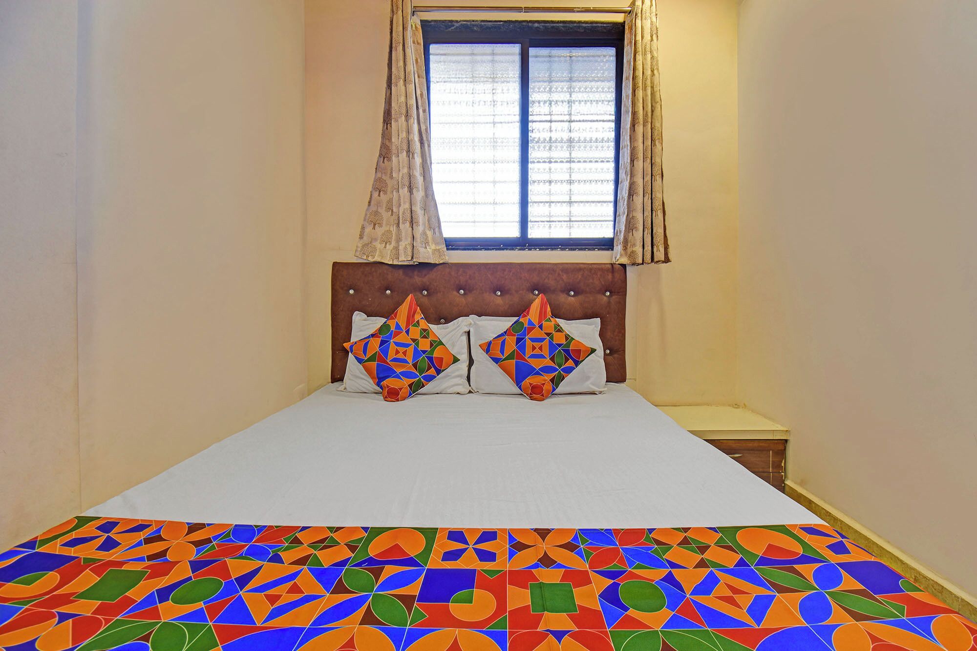 Quarto com cama, janela com cortinas e cabeceira.