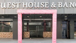 The entrance to West House & Ban Hotel with a stone facade and a glass door. - FabHotel Om Guest House & Banquet (Kolkata)